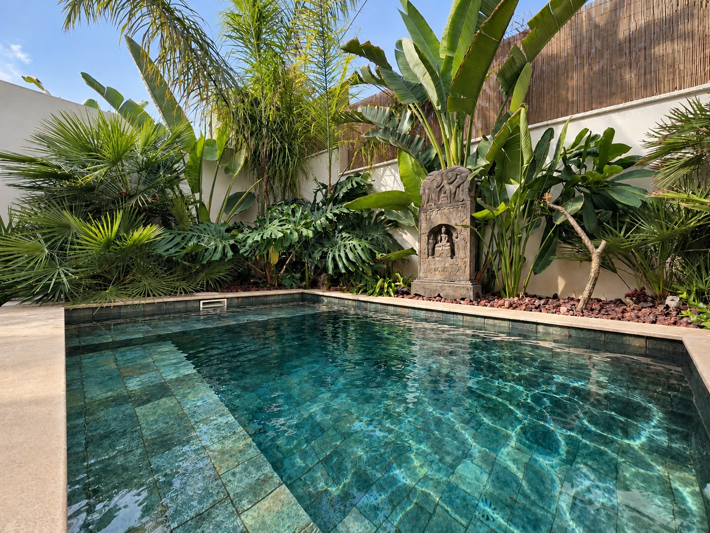 Clear water in the heated saltwater pool surrounded by tropical garden planting