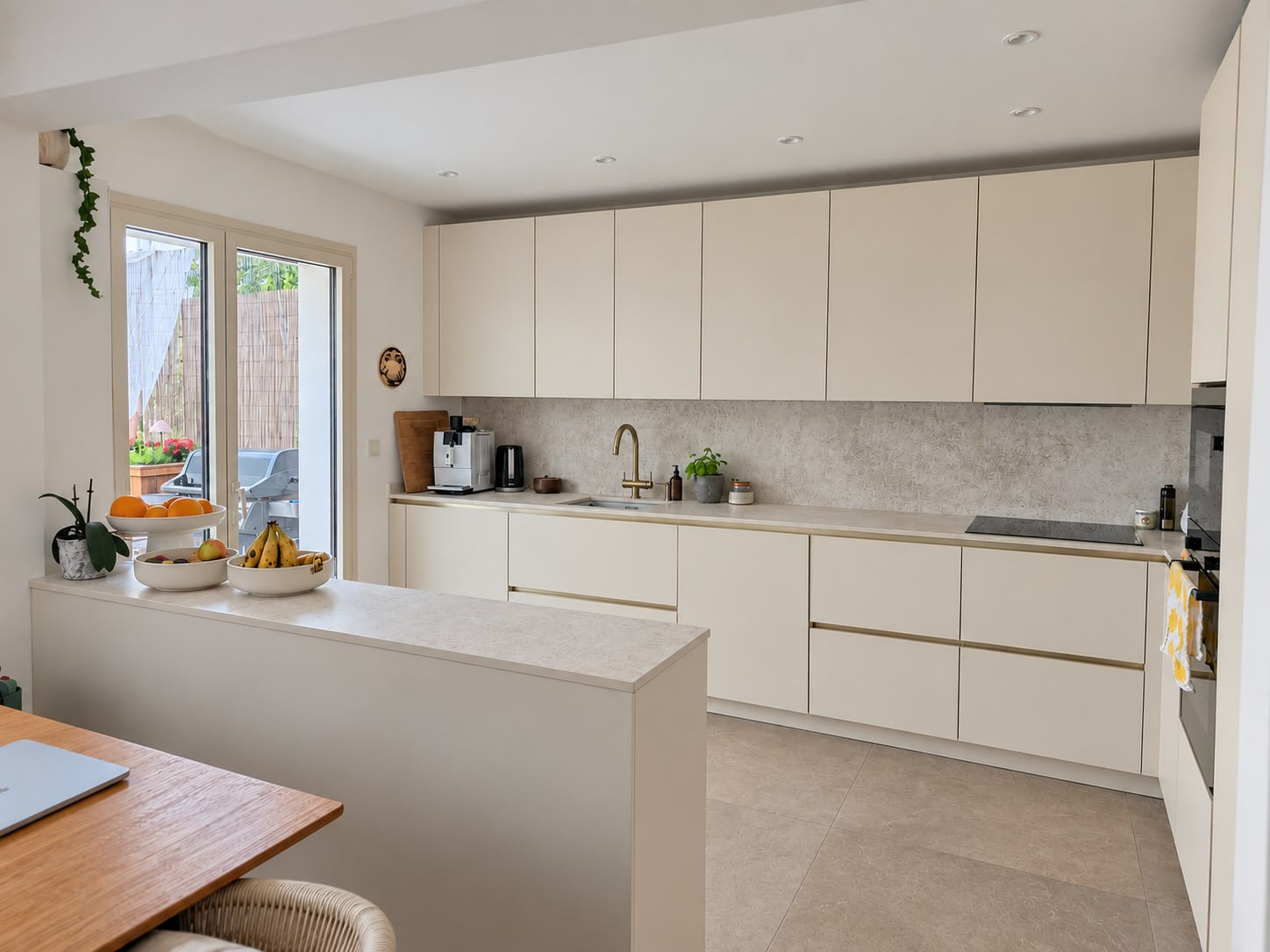 Renovated kitchen with light cabinetry and stone worktops